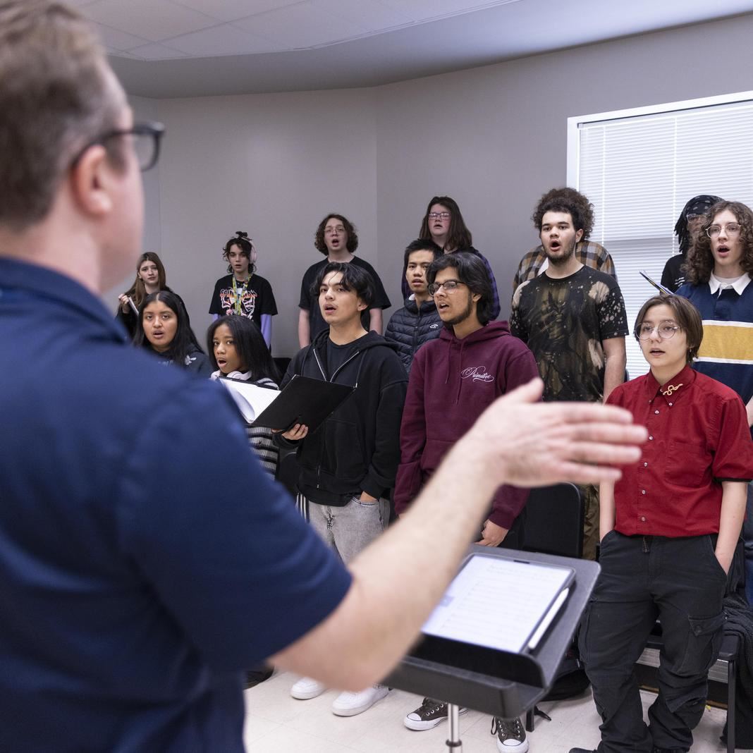 Students rehearse choir music 